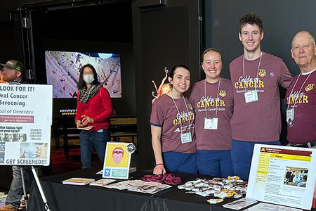 Three students and Nelson Rhodus pose at the Goldy vs. Cancer booth