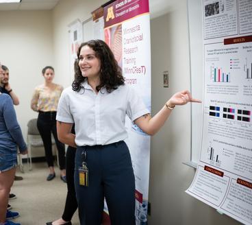 Student presenting research on a printed poster