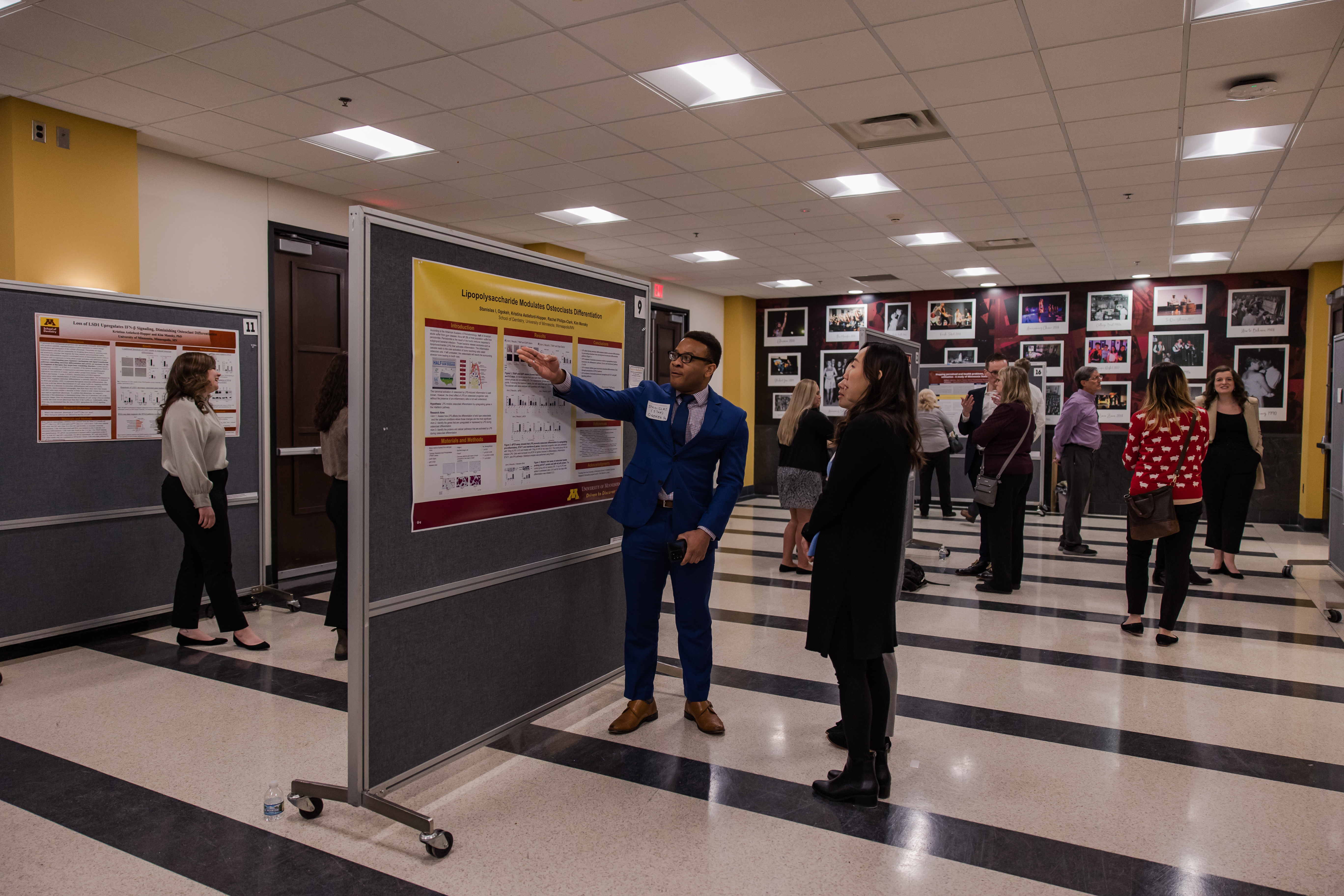A student researcher discusses his poster with attendees