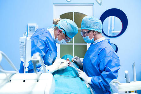 Two oral surgeons working on patient.