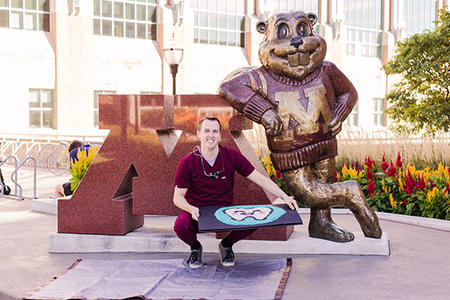 Tim Bitner poses with his rice creation in front of Goldy Gopher