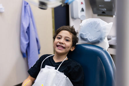 Child smiles in dental chair 