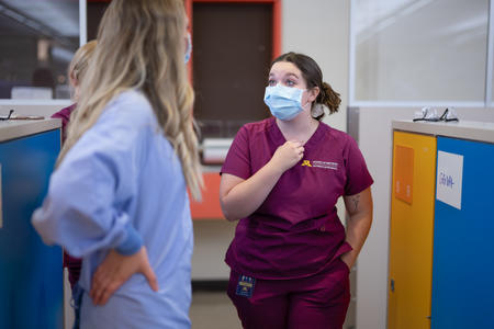 A dental hygiene student speaks with a faculty member
