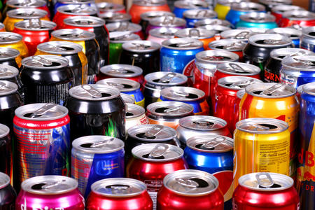 An assortment of opened, caffienated cans of soda and other beverages