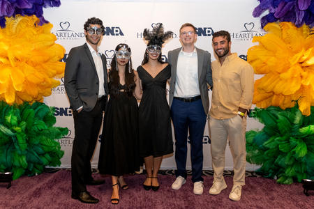 Five students in masquerade masks and formalwear at the SNDA conference