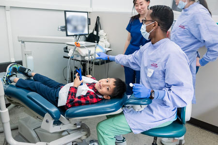 Child smiles while receiving dental care