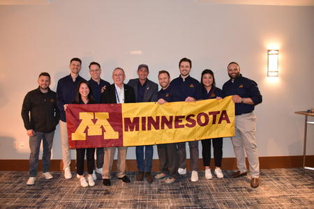 A group of endodontics residents and faculty pose with a Minnesota flag