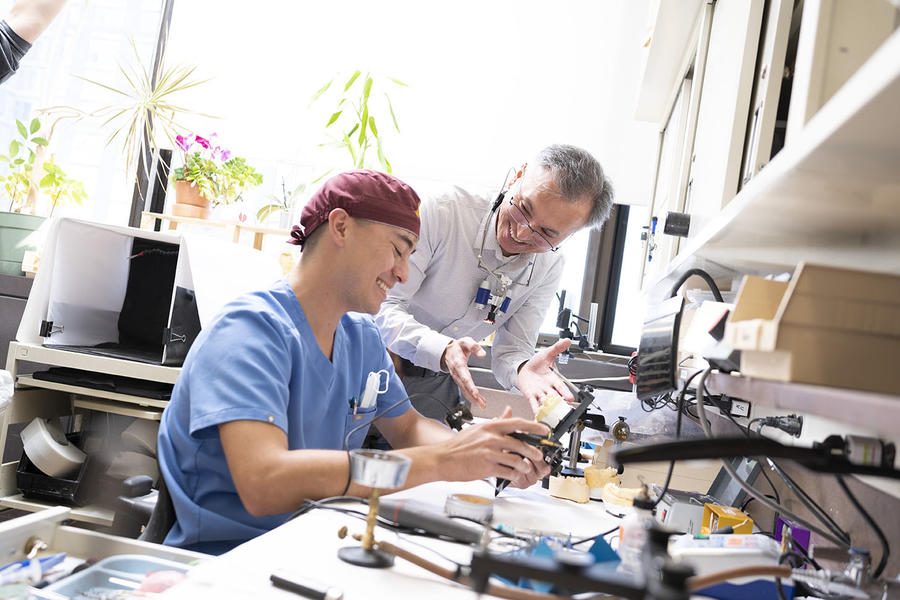Program Director Fengyuan Zheng works with a prosthodontics resident