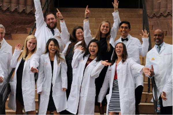 Doctor of Dental Surgery students posed with their white coats outside