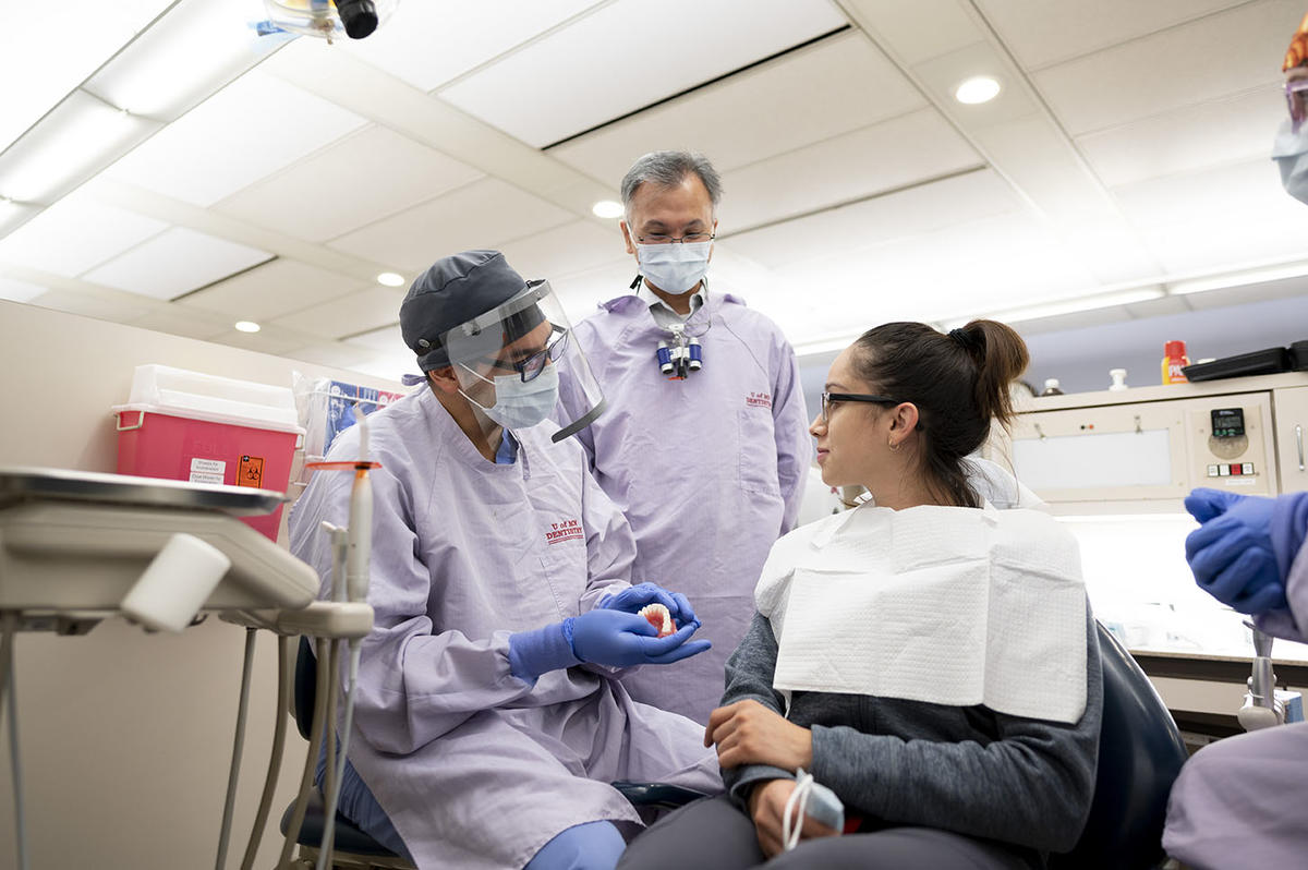 Prosthodontics residents and faculty discuss care with a patient