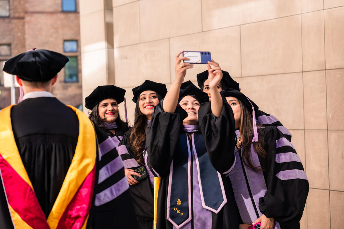 Graduates take a selfie outside 