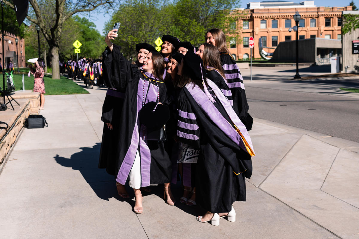 Graduates take a selfie outside 