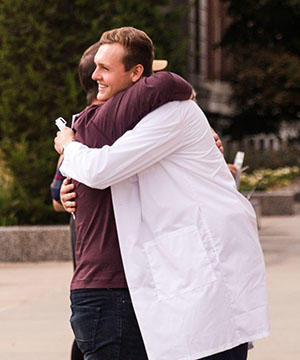 Second year students receives a hug following the White Coat Ceremony
