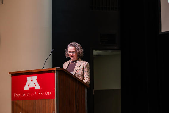 Kristin Artinger speaks from a podium at Research Day