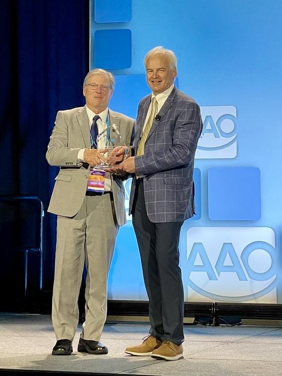 Brent Larson receives his award onstage at AAO