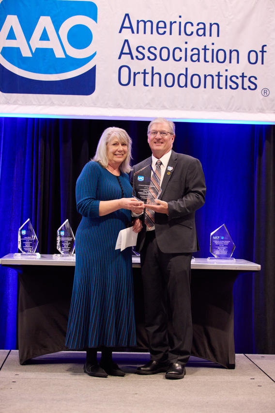 Cheryl Anderson Cermin poses with her award with AAO President Myron Guymon