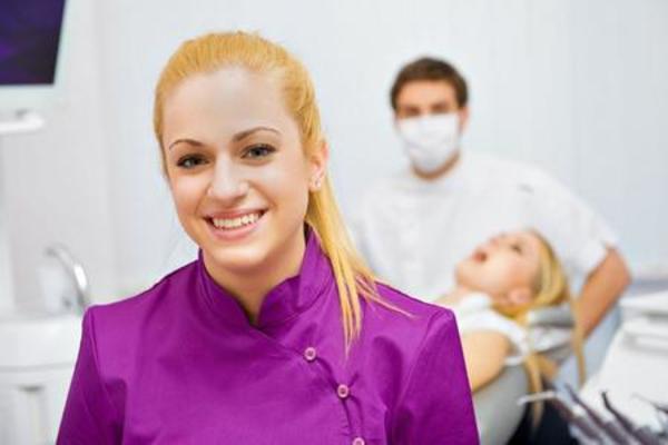 Woman smiling in front of people in dentist office.