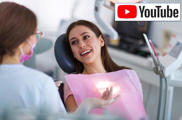 female patient in dental chair speaks with dentist
