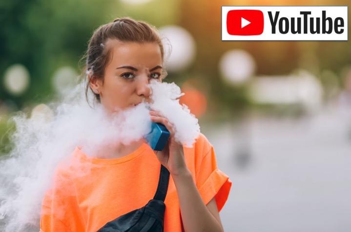 young woman vaping and producing a cloud of vapor