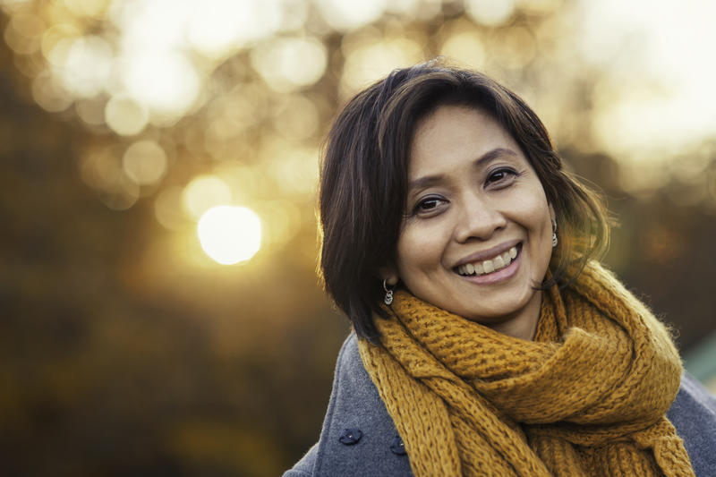 woman wearing scarf smiling with outdoor background