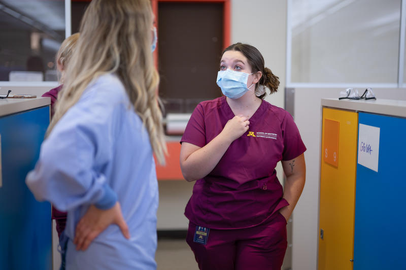 A dental hygiene student speaks with a faculty member