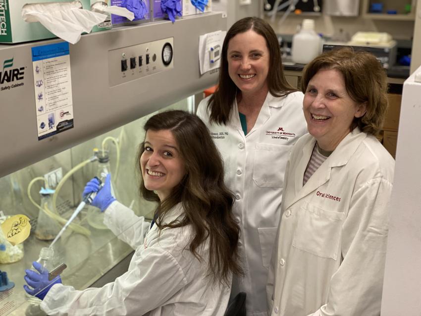 Rachel Phillips, Amy Tasca and Kim Mansky smile while working in a research lab