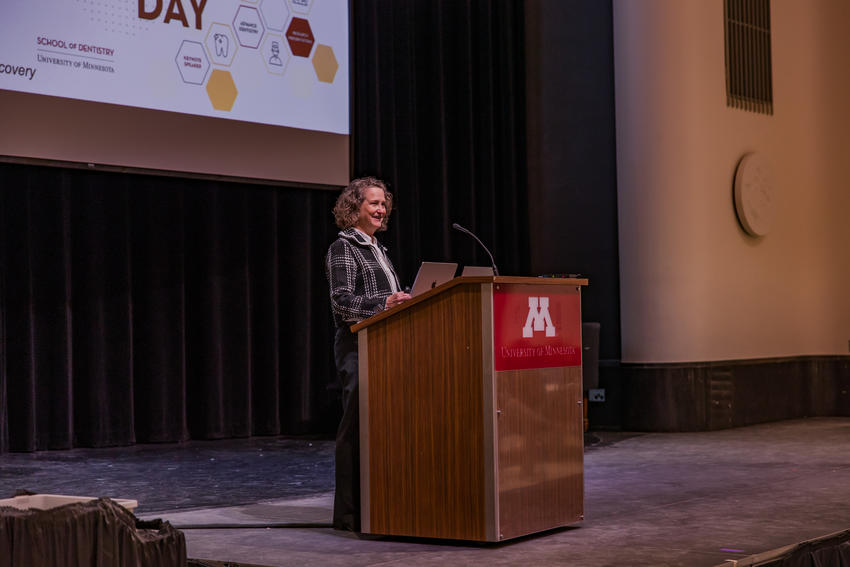 Kristin Bruk Artinger speaks from a podium at Research Day