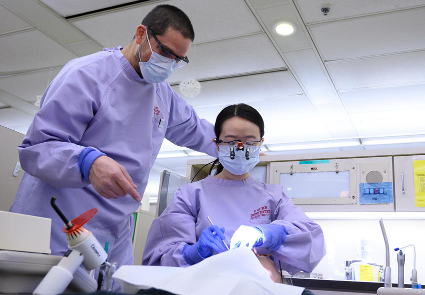 Two University of Minnesota dentists provide care to a patient in our clinic