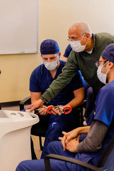 Omar Zidan instructs DDS learners on a CAD/CAM device