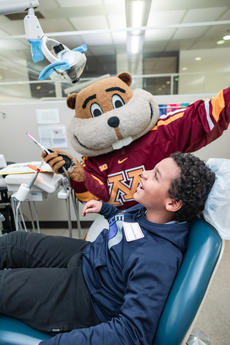 Goldy pretends to provide dental care to a child