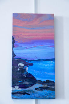 Layers of acrylic paint in pink, blue and gray create a sunset with waves crashing against a rock