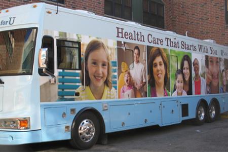 mobile dental clinic. a light blue full-size city bus decorated with images of patients