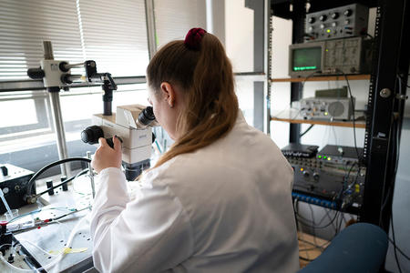 Researcher examining a specimen with a microscope