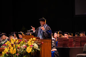 Mays speaks at a podium during commencement